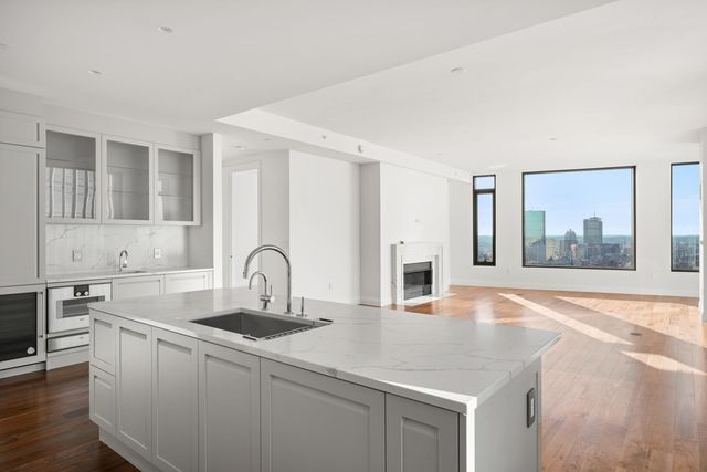 a kitchen with stainless steel appliances granite countertop a sink and white cabinets with wooden floor