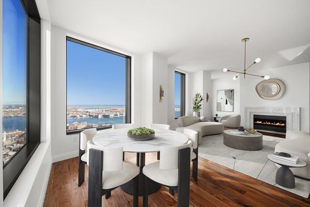 a view of a dining room with furniture a chandelier and wooden floor