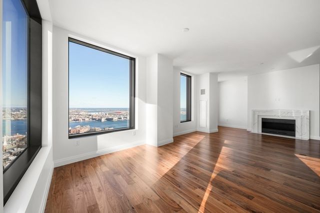 a view of a hallway with wooden floor and a fireplace