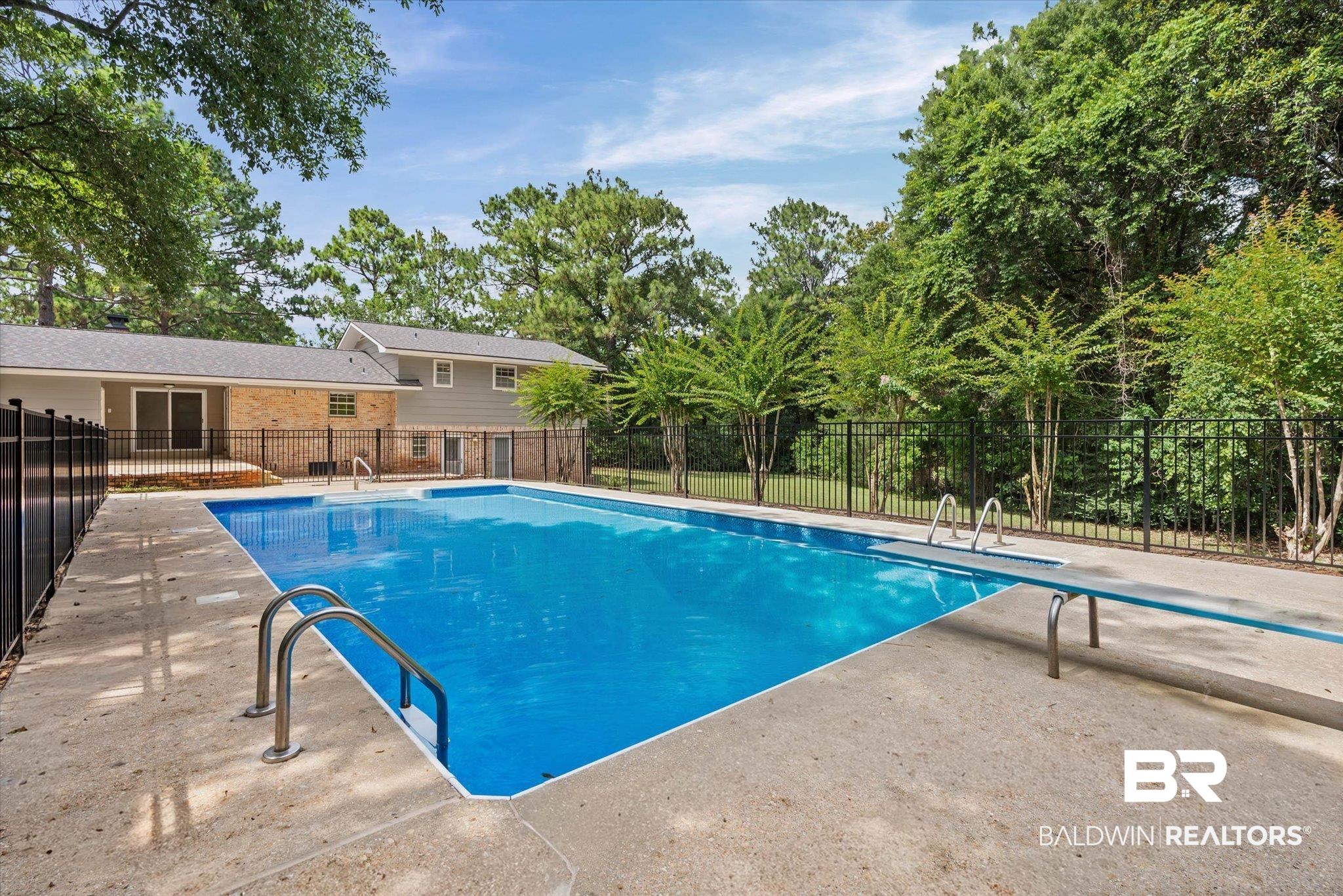 8301 Fordham Road Mobile, AL 36619 - Photo 30 of 57 Rectangular in-ground pool with an integrated diving board and perimeter safety fencing