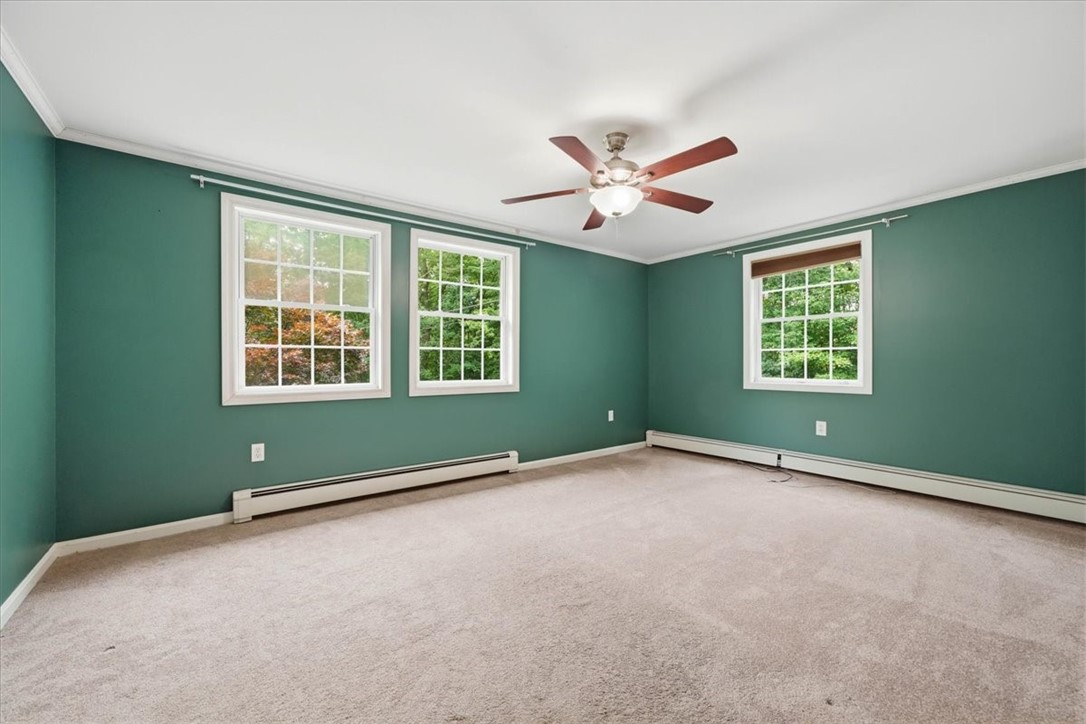 214 Anan Wade Road Glocester, RI 02857 - Photo 19 of 50 Spacious primary bedroom with multiple windows, abundant natural light, a ceiling fan and generous double-door closet.