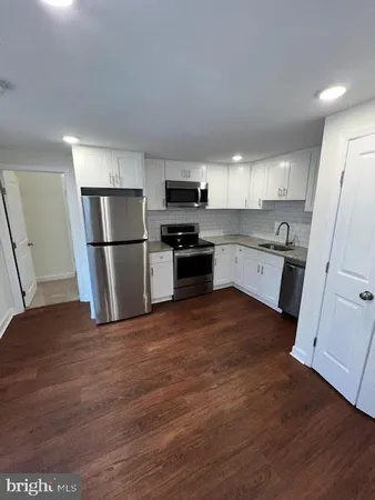 a kitchen with a refrigerator a sink and a stove top oven