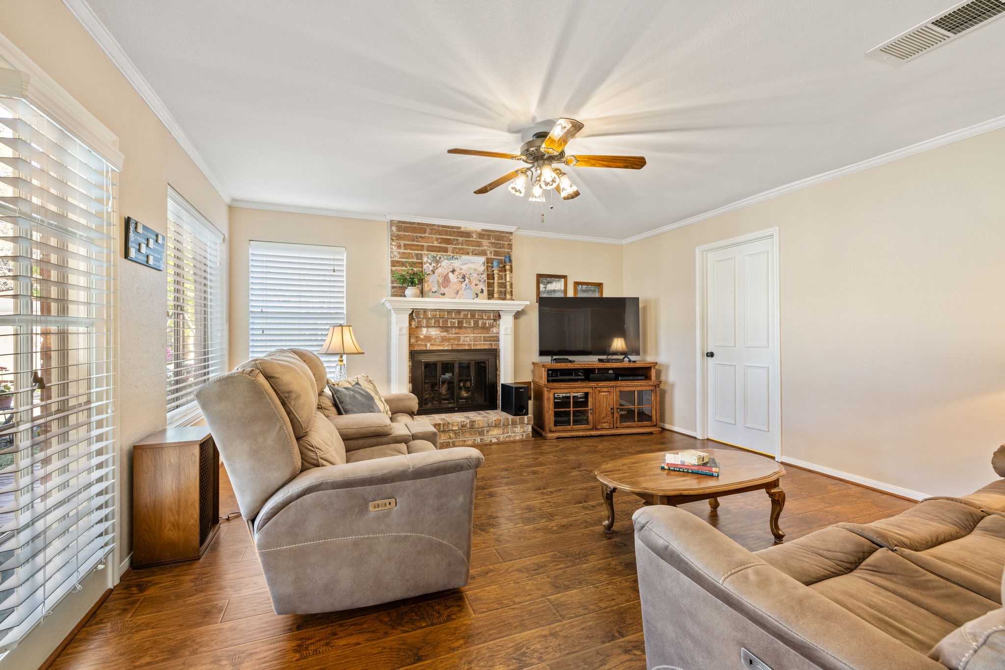9102 Woodhouse Drive Spring, TX 77379 - Photo 12 of 32 FAMILY ROOM - This room has neutral paint, high-end laminate flooring and lots of windows. The doorway leads to the utility room, and then to the garage. Nice and bright room with gas fireplace.