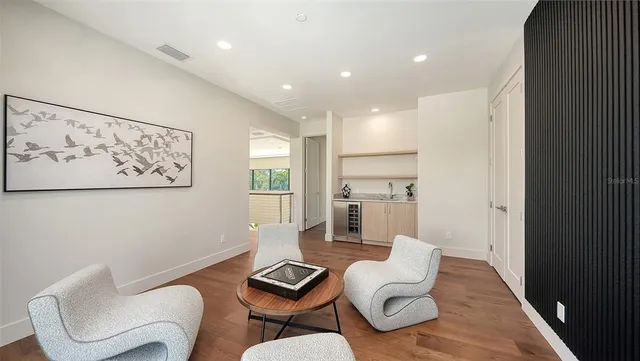 a view of a patio with table and chairs potted plants and floor to ceiling window