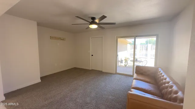 a living room with furniture and a ceiling fan