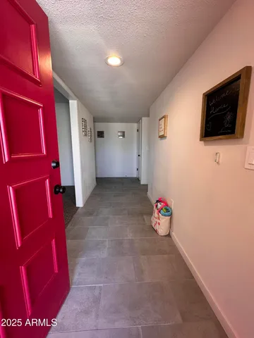 a view of an empty room with wooden floor and windows