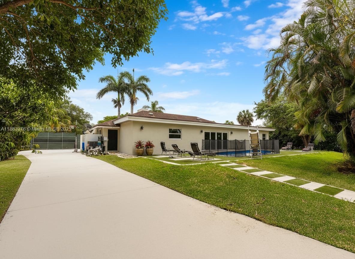 14401 Southwest 23rd Street Davie, FL 33325 - Photo 36 of 56 a front view of a house with a garden and trees