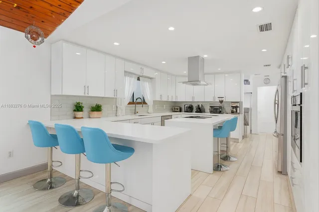 a kitchen with stainless steel appliances kitchen island granite countertop a refrigerator and a stove top oven