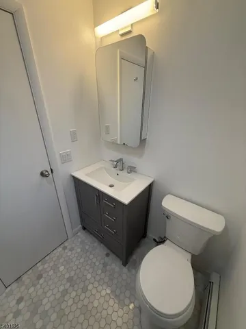 a bathroom with a sink vanity mirror and toilet