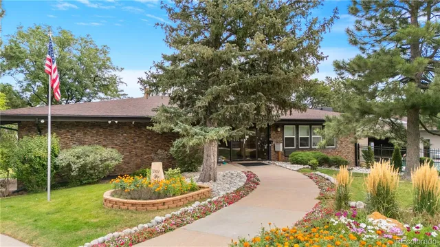a front view of a house with a yard fountain and outdoor seating