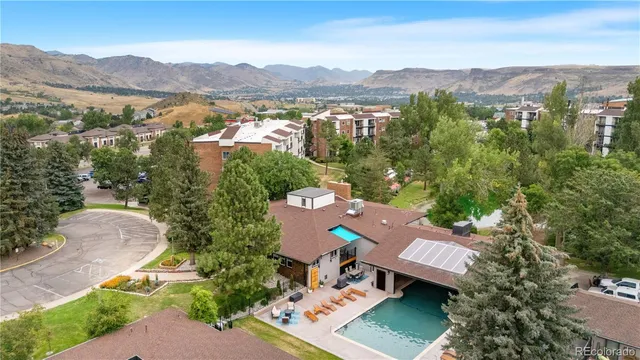 an aerial view of a city with lots of residential buildings and mountain view in back