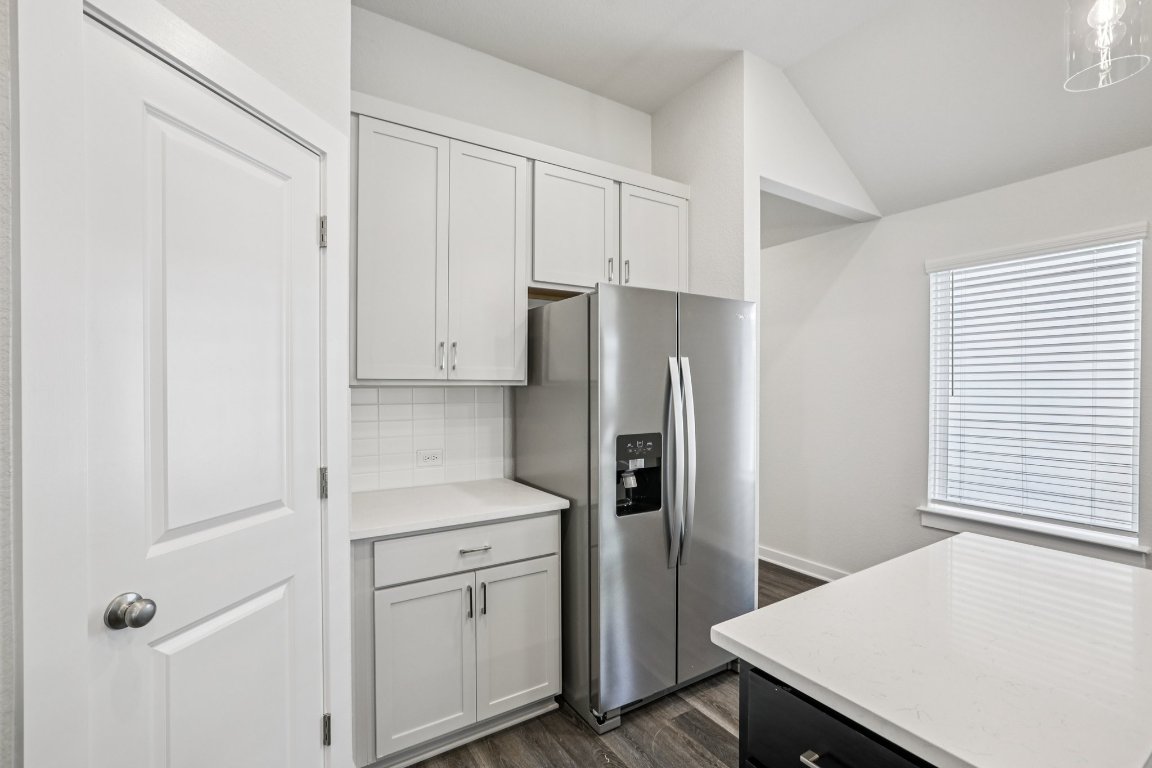 2304 Delano Drive Leander, TX 78641 - Photo 15 of 31 a kitchen with a refrigerator and white cabinets
