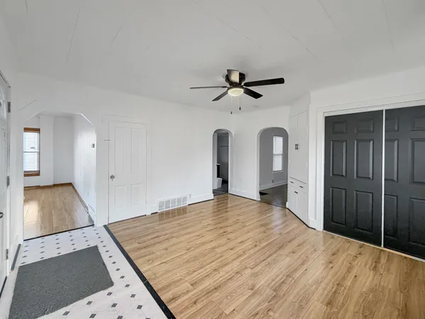 a view of a room with wooden floor and ceiling fan