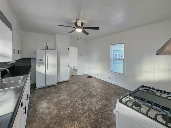 a kitchen with a stove a refrigerator and a sink