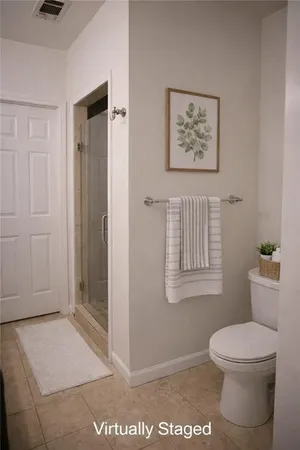 a bathroom with a granite countertop toilet and a shower
