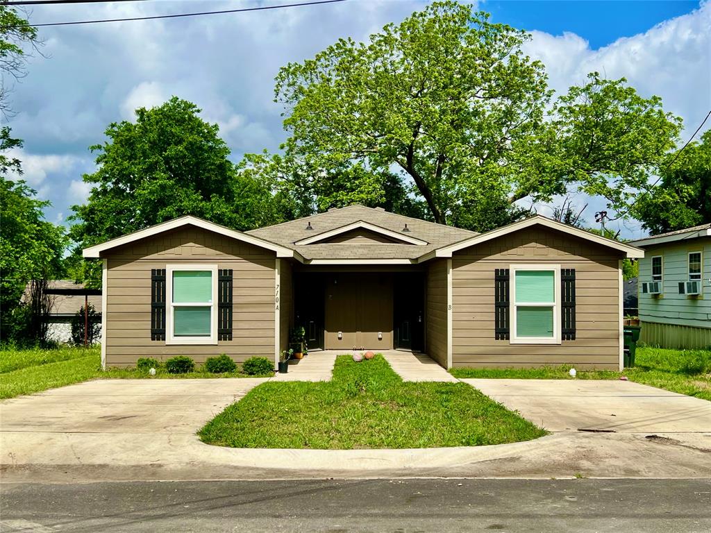 a front view of a house with a garden