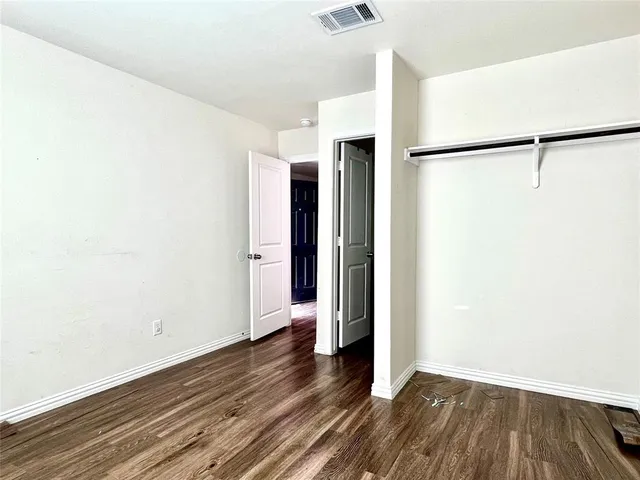 a view of a room with wooden floor