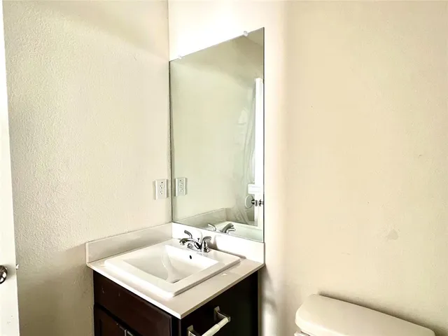 a bathroom with a sink toilet and mirror