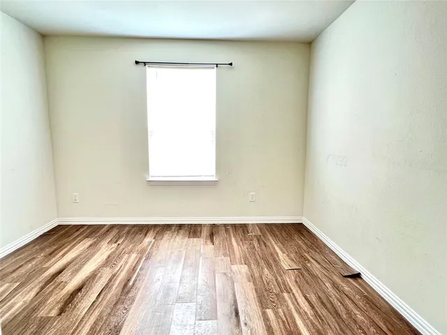 a view of a room with wooden floor and a window