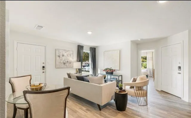 a living room with furniture a wooden floor and a potted plant