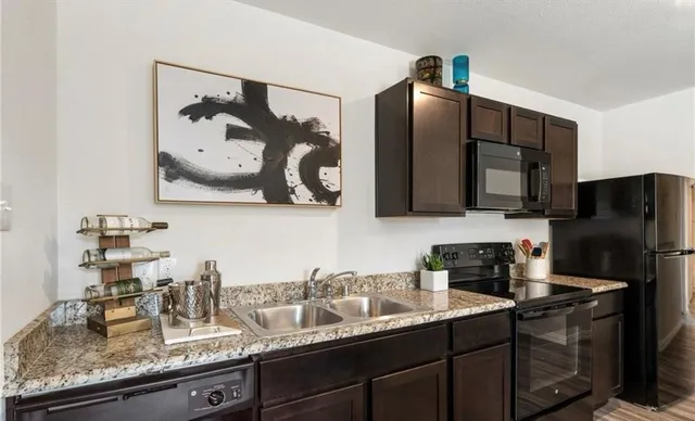 a kitchen with stainless steel appliances granite countertop a sink stove and refrigerator