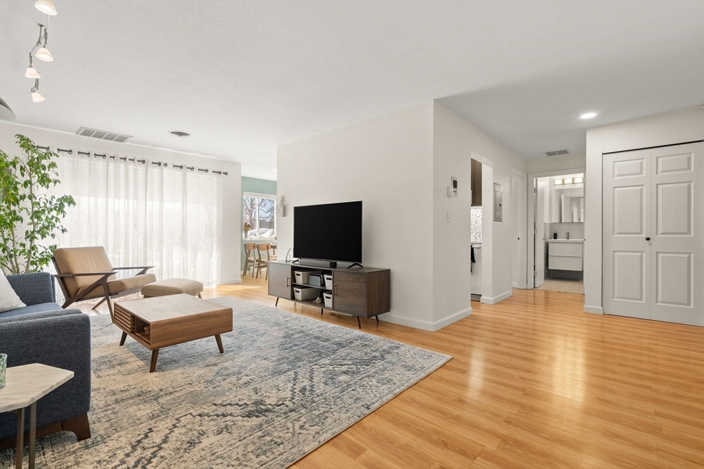1206 Greendale Avenue, Unit 217 Needham, MA 02492 - Photo 1 of 33 a living room with furniture and a flat screen tv
