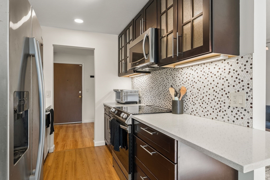 1206 Greendale Avenue, Unit 217 Needham, MA 02492 - Photo 12 of 33 a kitchen with a stove and a wooden floor