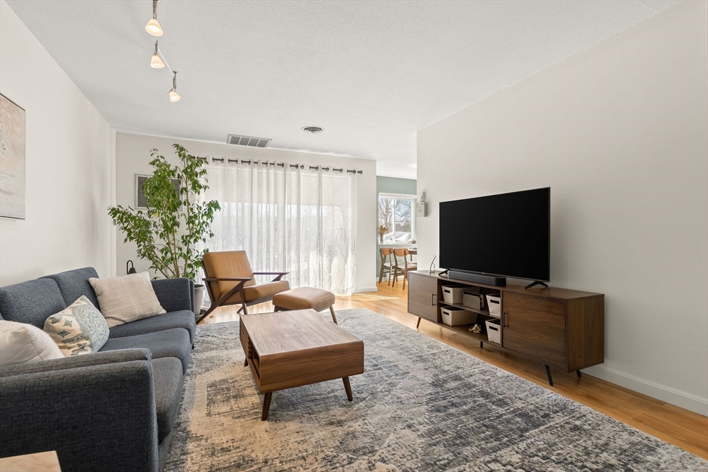1206 Greendale Avenue, Unit 217 Needham, MA 02492 - Photo 2 of 33 a living room with furniture and a flat screen tv