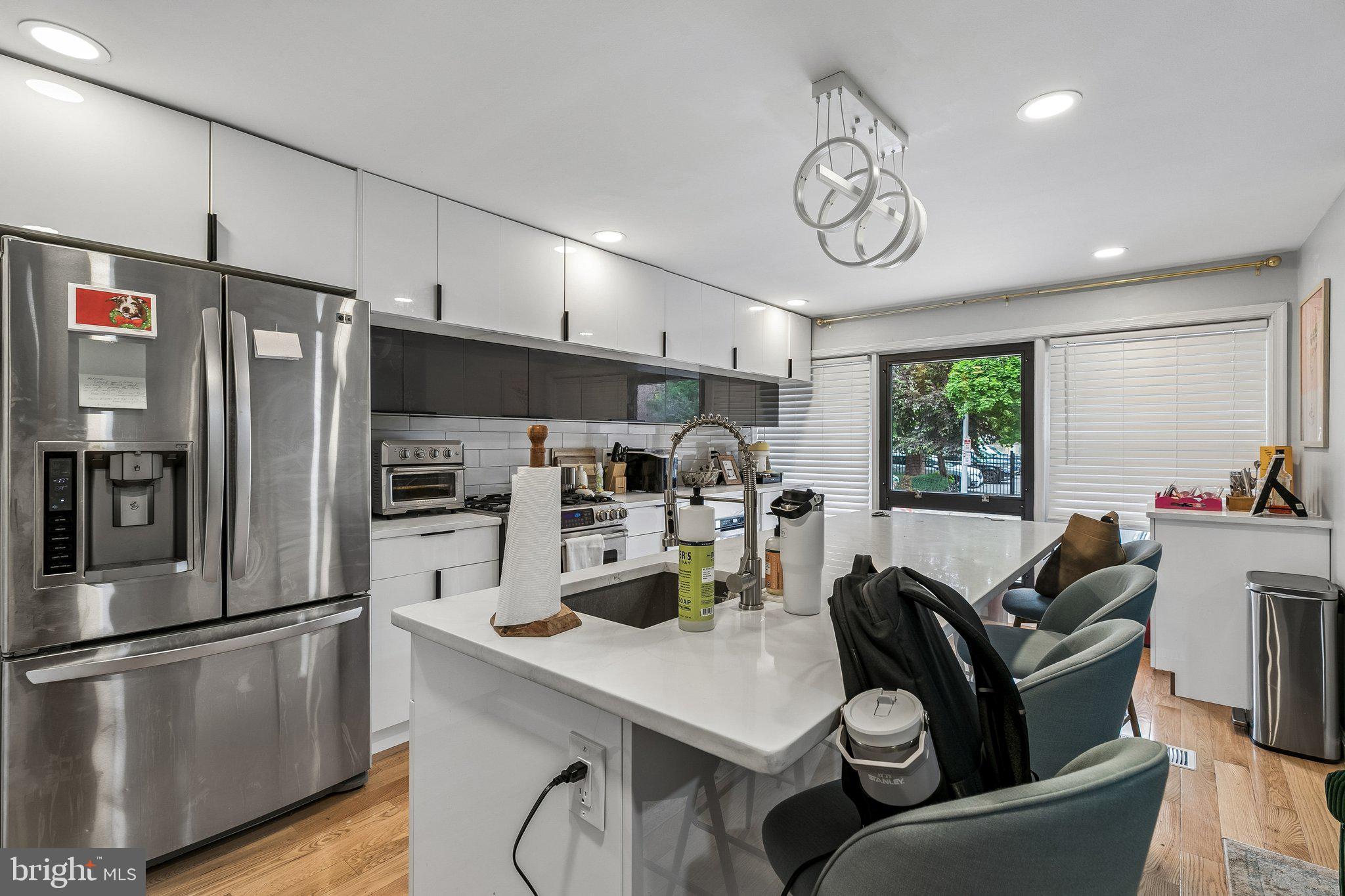 1130 Lombard Street Philadelphia, PA 19147 - Photo 7 of 45 a kitchen with stainless steel appliances a table chairs and a refrigerator