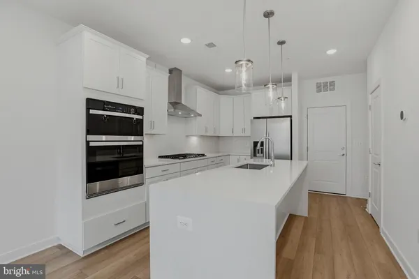a kitchen with stainless steel appliances a stove a sink and a refrigerator