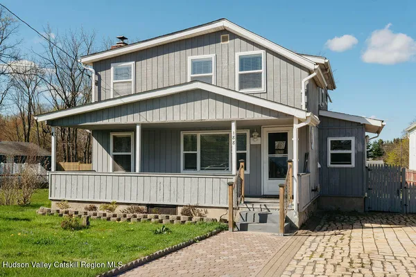 a front view of a house with a yard and outdoor seating