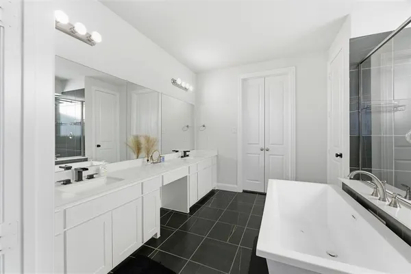 a bathroom with a tub sink and mirror