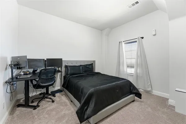 a bedroom with a bed and a desk