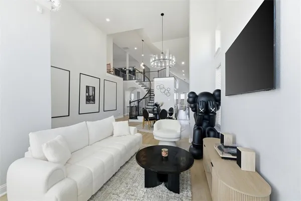 a living room with furniture a flat screen tv and kitchen view