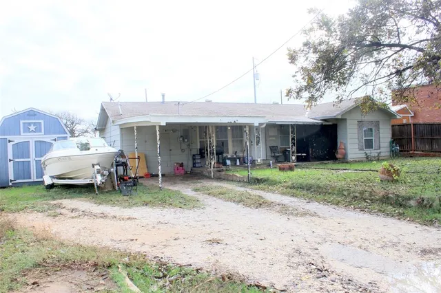 a view of a house with a chairs and table in a yard