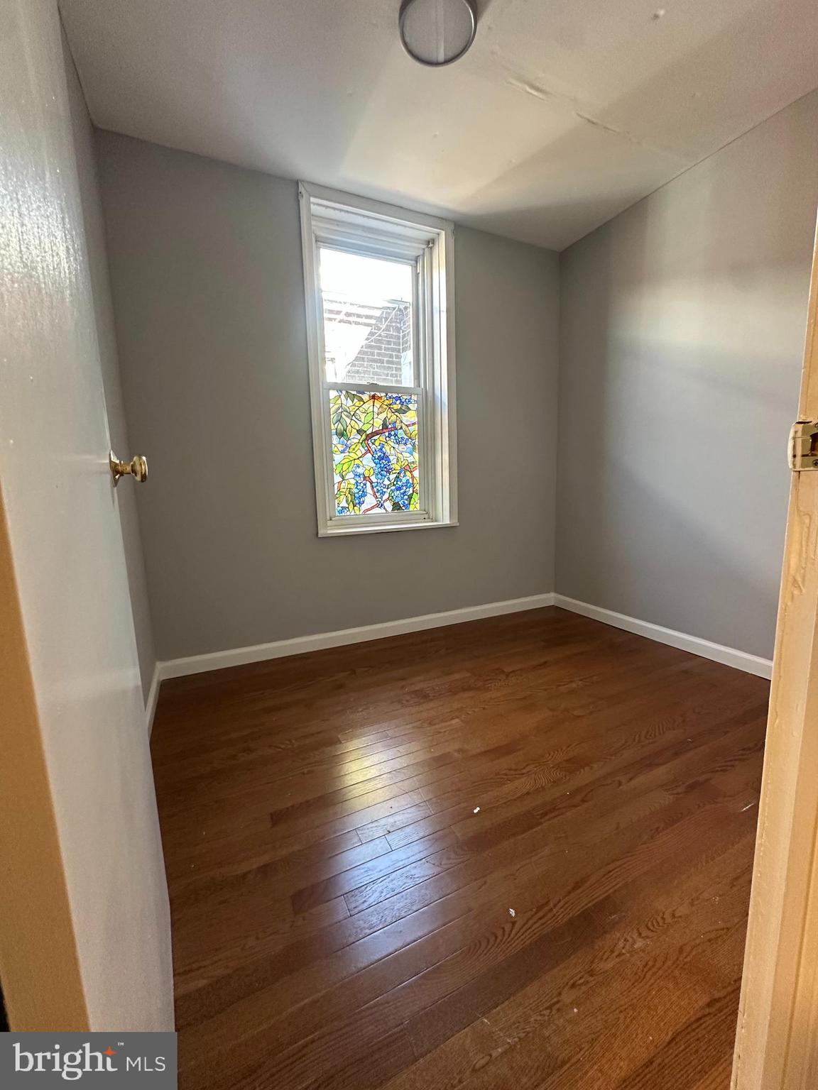 2812 Emerald Street Philadelphia, PA 19134 - Photo 13 of 25 an empty room with wooden floor and windows