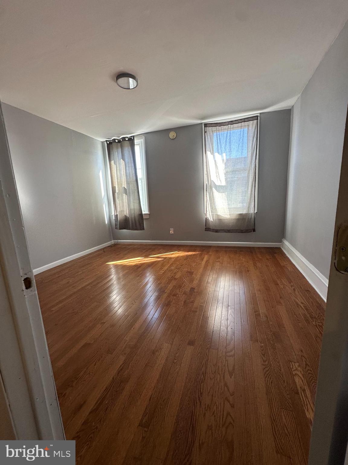 2812 Emerald Street Philadelphia, PA 19134 - Photo 14 of 25 an empty room with wooden floor and windows