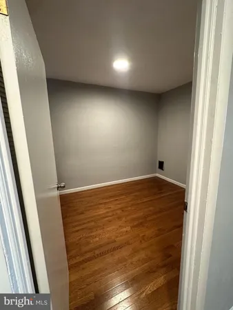 an empty room with wooden floor and entrance
