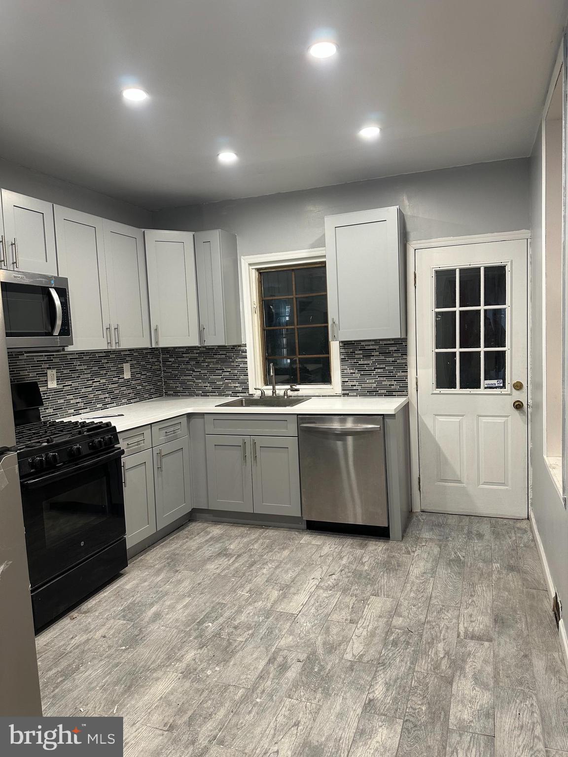 2812 Emerald Street Philadelphia, PA 19134 - Photo 2 of 25 a kitchen with stainless steel appliances a sink a stove a microwave a sink a refrigerator and cabinets