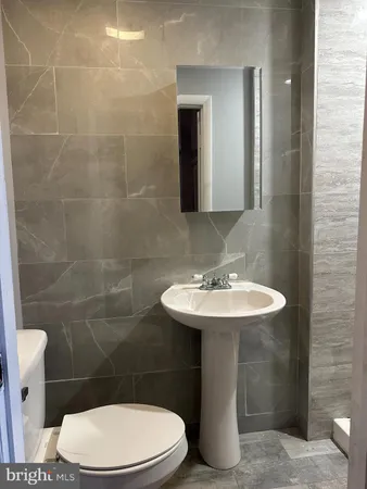 a bathroom with a sink a toilet and a mirror