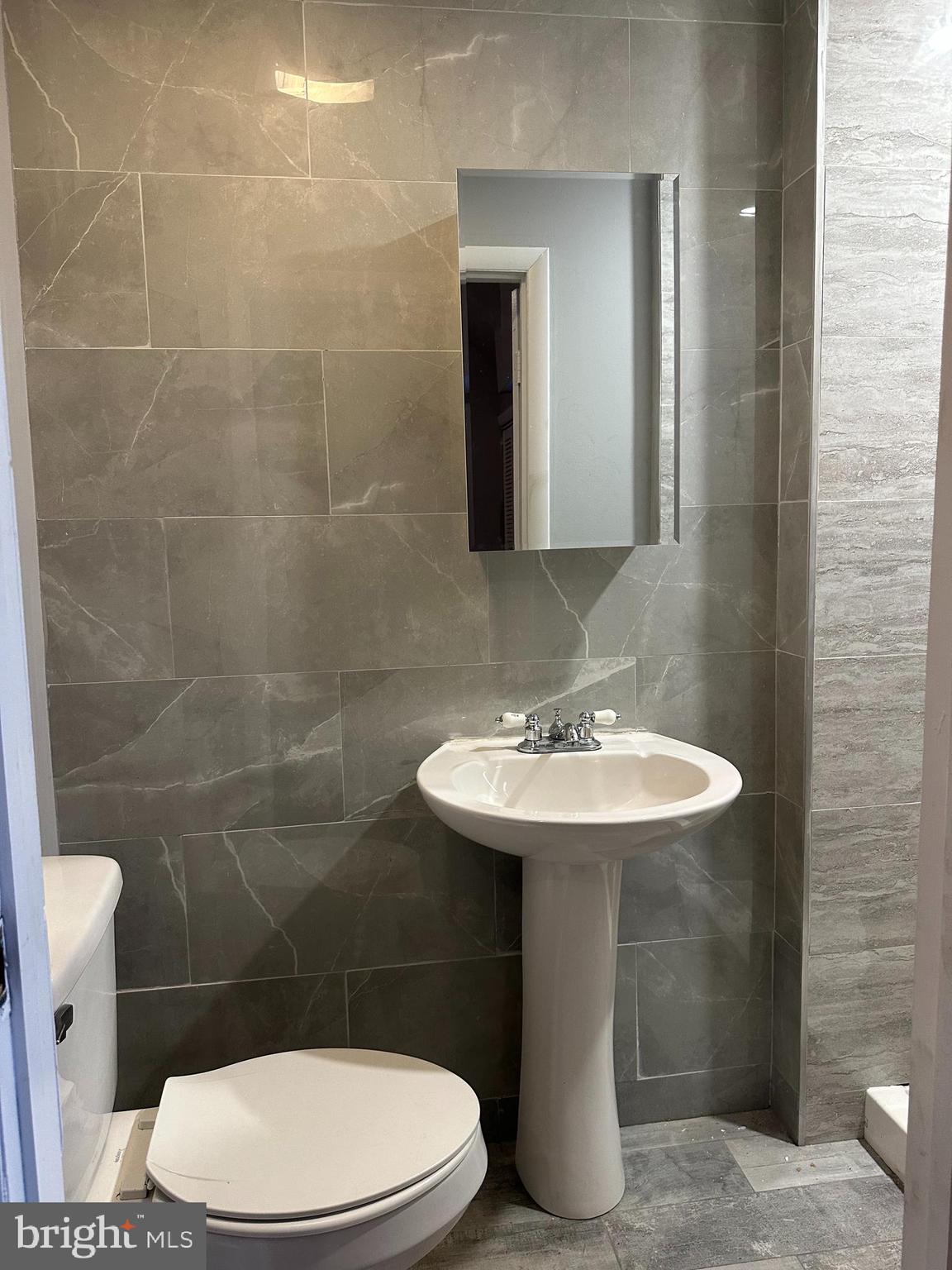 2812 Emerald Street Philadelphia, PA 19134 - Photo 8 of 25 a bathroom with a sink a toilet and a mirror