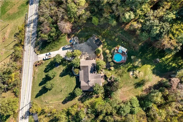 an aerial view of a house with a yard and swimming pool