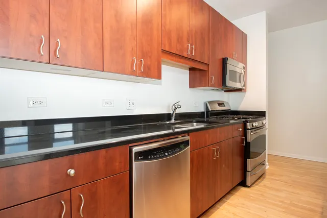 a kitchen with stainless steel appliances granite countertop a sink and a microwave