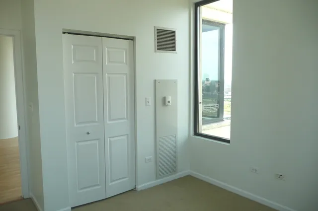 an empty room with windows and closet