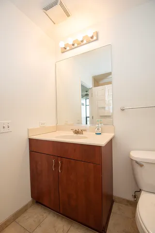 a bathroom with a sink mirror vanity and toilet