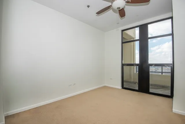 an empty room with a window and a ceiling fan