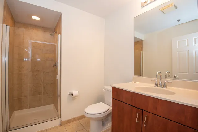 a bathroom with a sink a toilet a mirror and shower