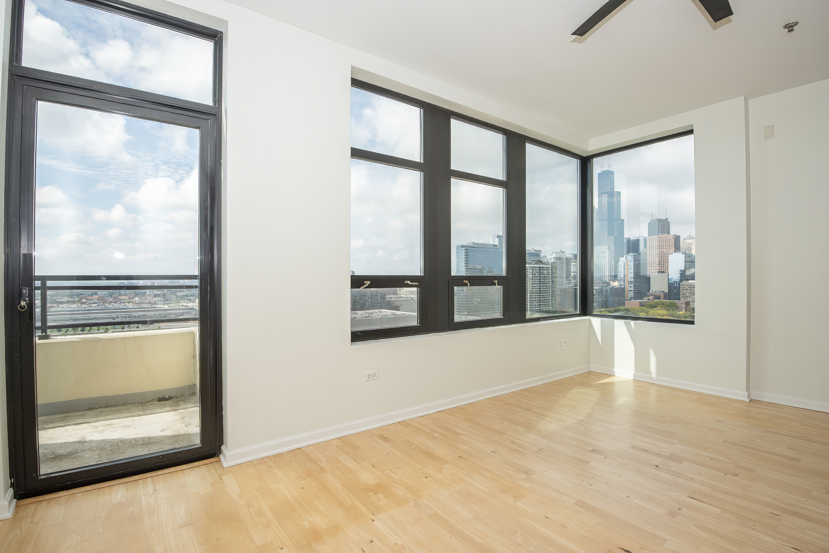 1255 South State Street, Unit 1902 Chicago, IL 60605 - Photo 6 of 33 a view of an empty room with a window and a kitchen view