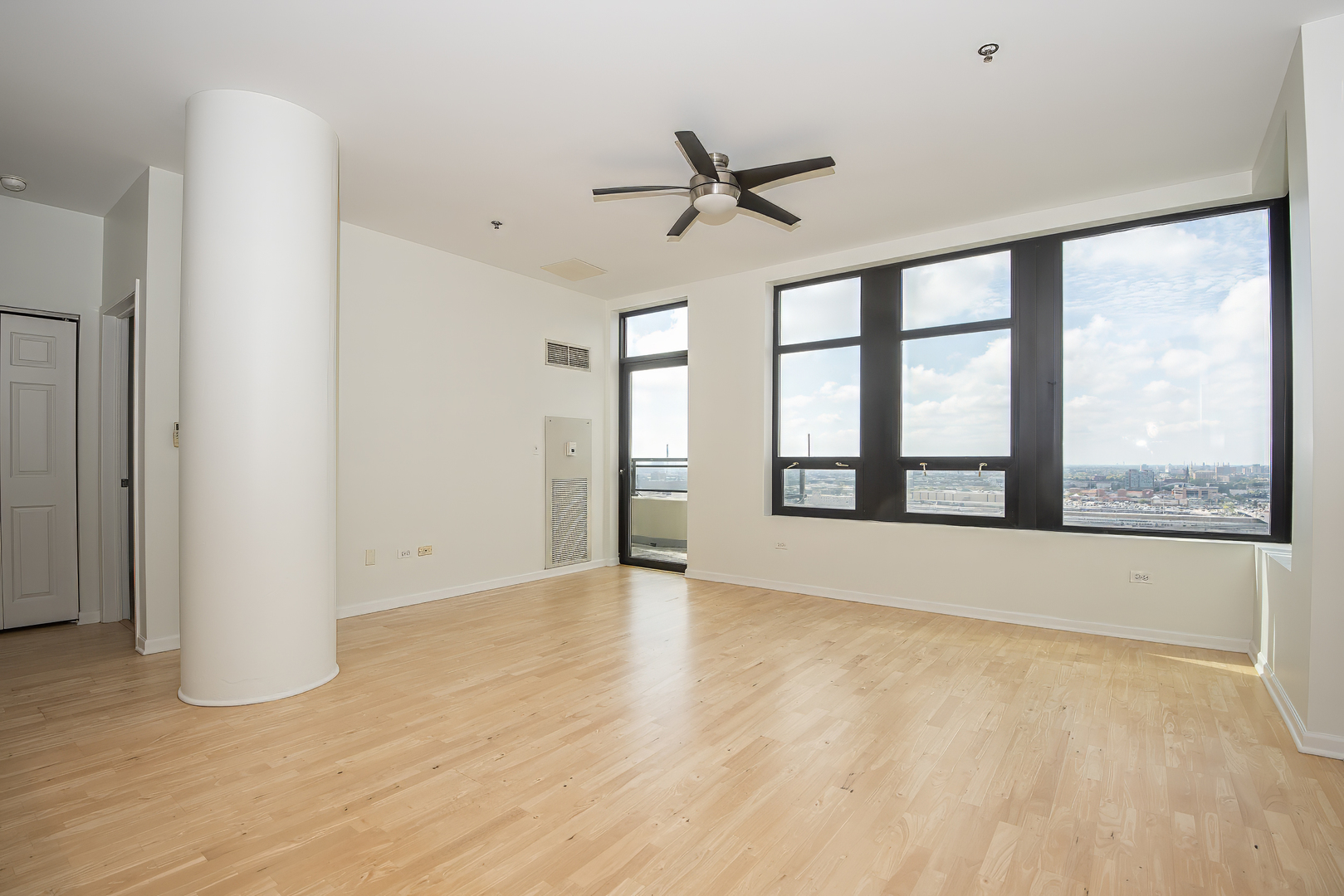 1255 South State Street, Unit 1902 Chicago, IL 60605 - Photo 7 of 33 a view of an empty room with a window and wooden floor