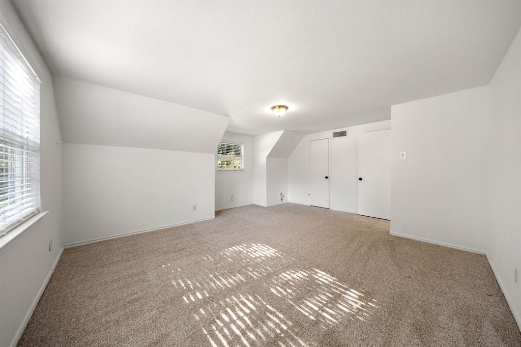 3060 Timberview Road Dallas, TX 75229 - Photo 23 of 39 Spacious room with plush carpeting, neutral wall finishes, and sloped ceiling details